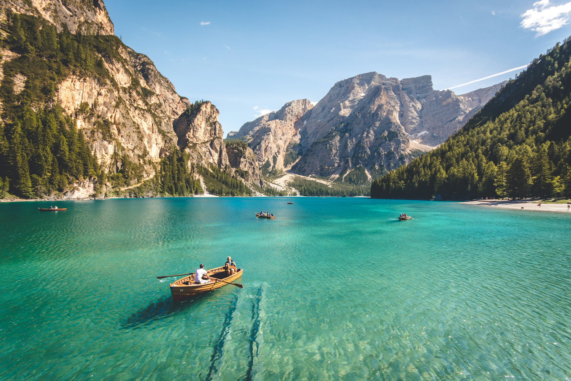 Bergsee mit Ruderbooten vor hohen Felswänden